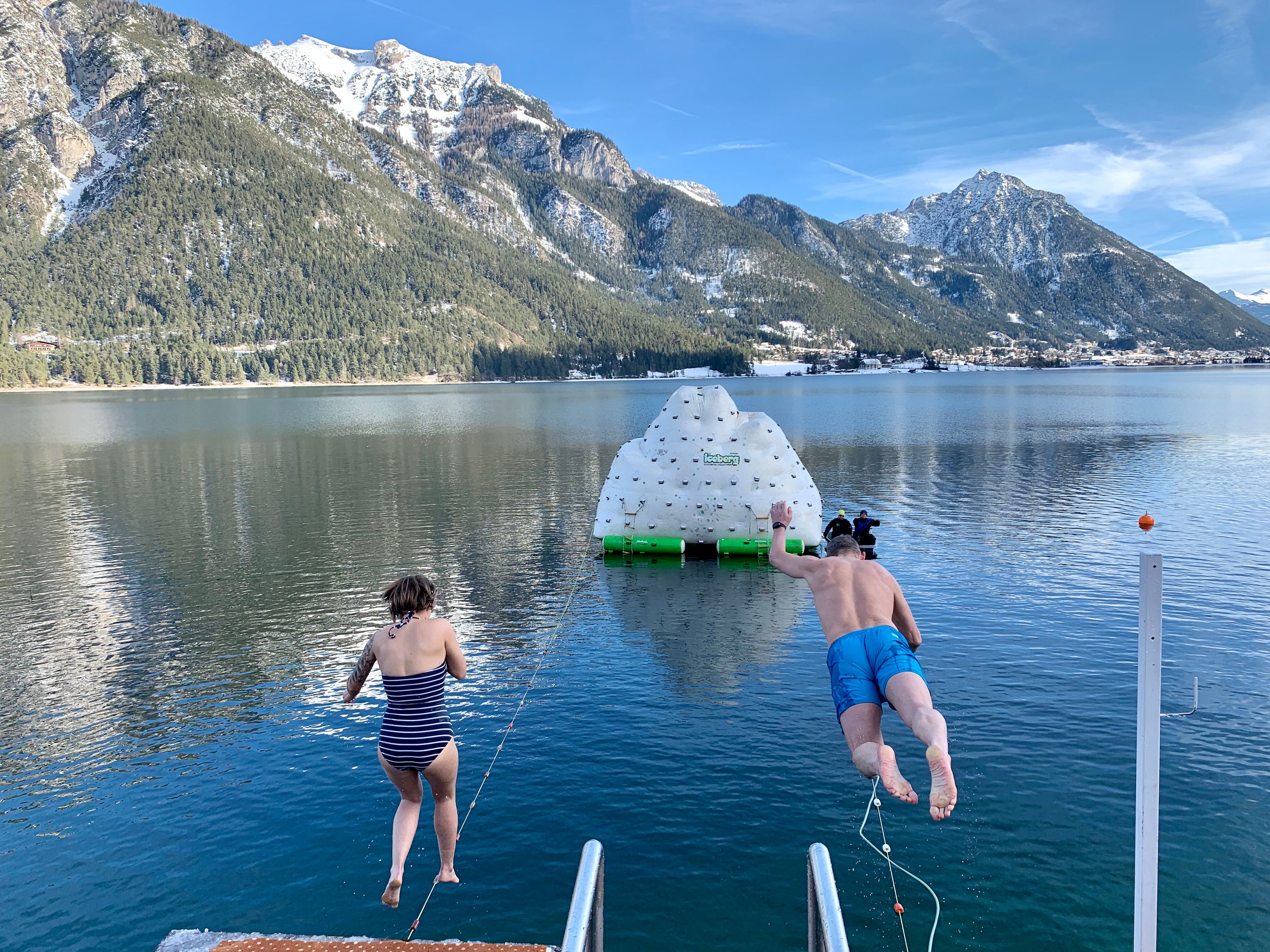 Zwei Schwimmer springen vom Steg in den eiskalten Achensee zu Silvester